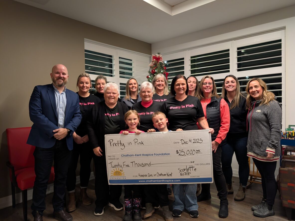 a group of people hold a large cheque